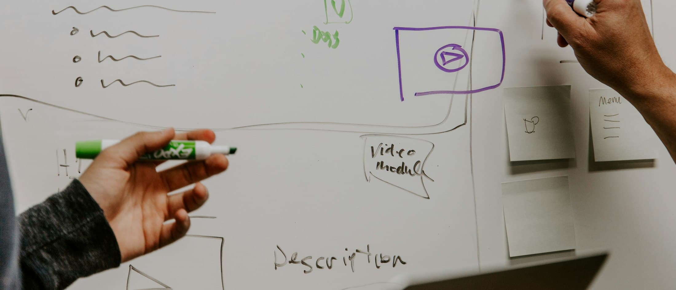 Dos personas dibujando un diagrama a mano sobre una pizarra blanca